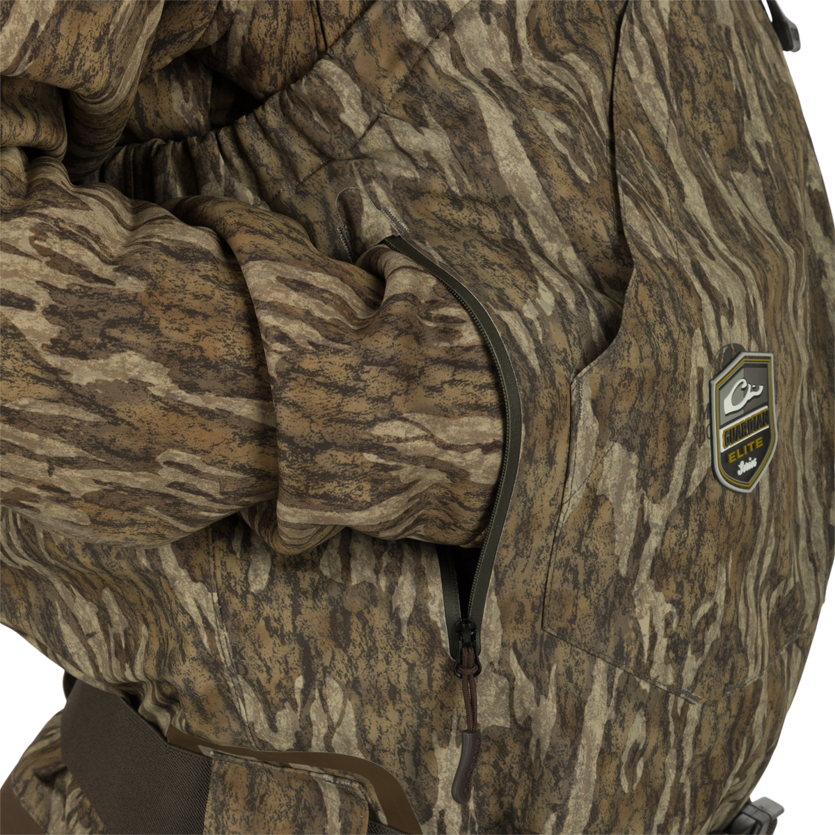 Person wearing the Insulated Guardian Elite HND Front Zip Wader, featuring camouflage design, reinforced seams, and Thinsulate® boot lining for cold weather hunting.